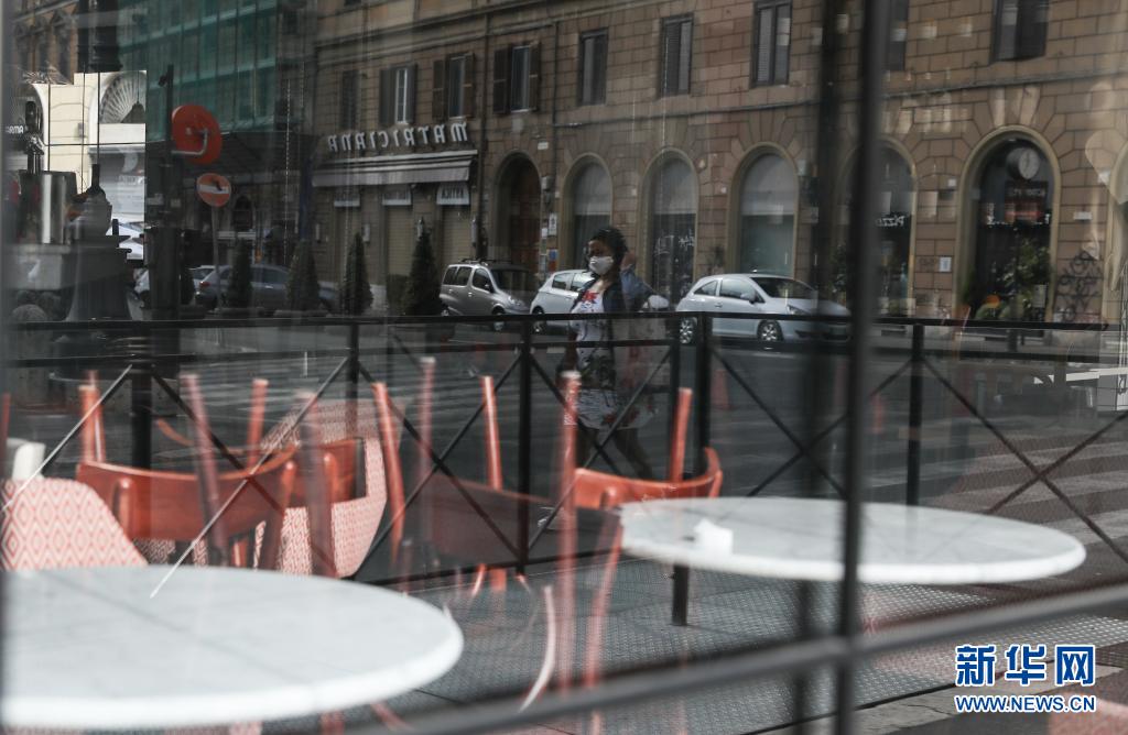 4月3日，一名女子走过意大利罗马一家关闭的餐馆。