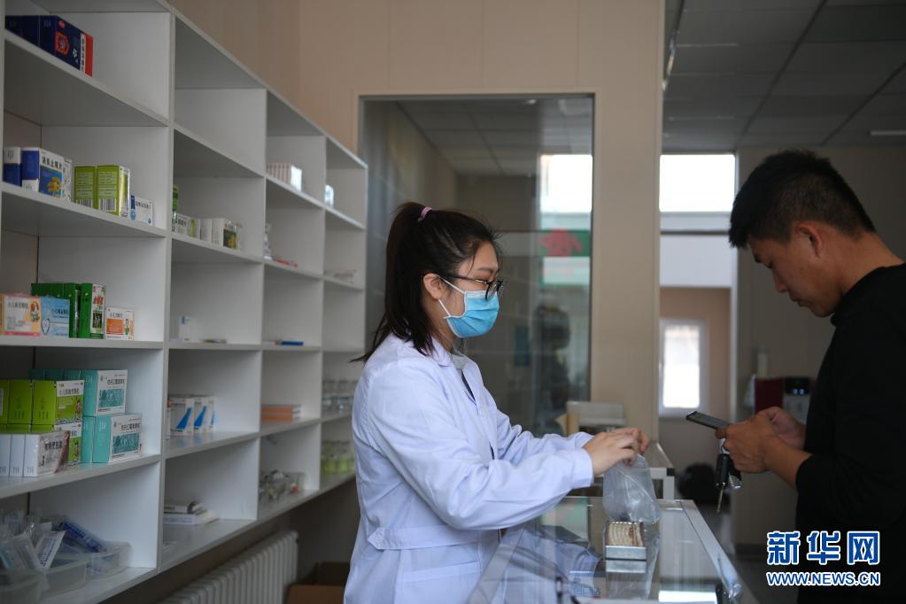 4月6日，在辽宁省东港市前阳镇前阳村卫生所，孙艺为患者取药。